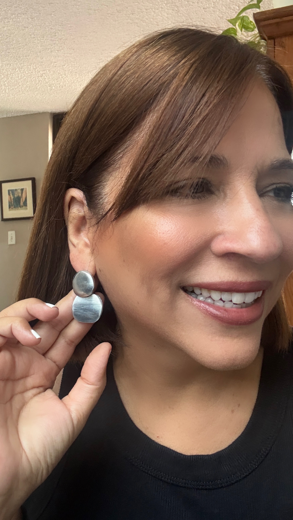 Vestopazzo 2 Round Drop Earrings – Smiling woman holding matte silver double disc drop earrings near ear with black top | Místika Style