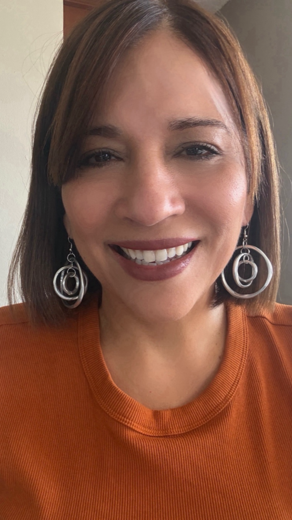 Vestopazzo 3 Circles Drop Earrings – Smiling woman wearing silver triple concentric ring drop earrings with orange ribbed sweater | Místika Style