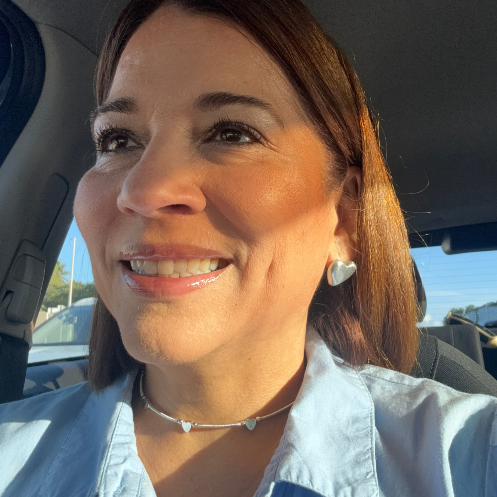 Vestopazzo Hearts Choker Necklace – Smiling woman wearing silver hearts choker necklace and matching heart stud earrings with blue top | Místika Style