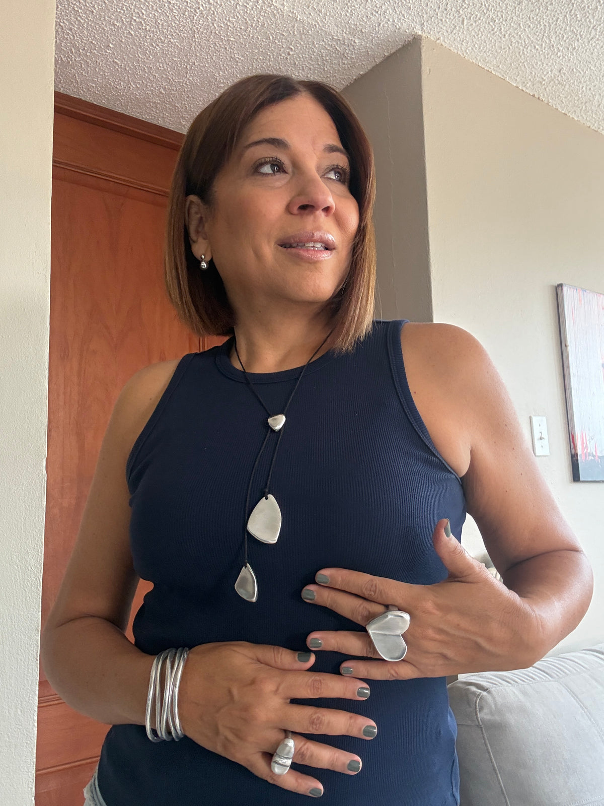 Vestopazzo Lariat Necklace – Woman wearing long silver lariat necklace with navy blue sleeveless top and silver bangle bracelet | Místika Style