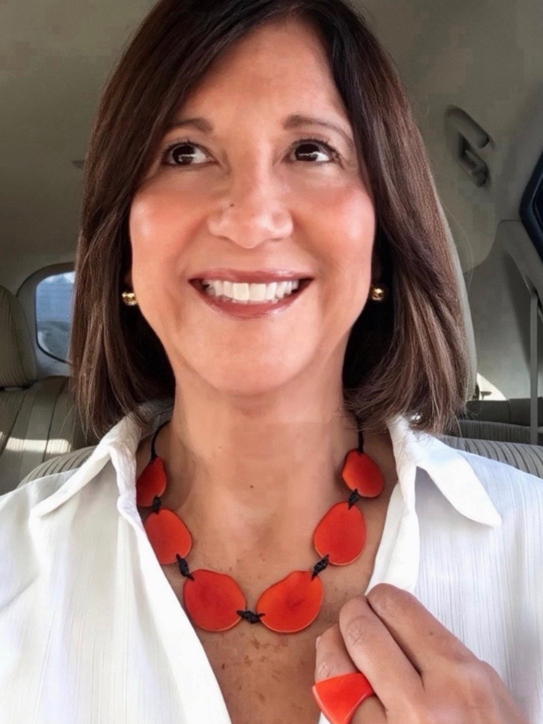 MÍSTIKA Tagua Sunlit Petals Necklace in Orange – Smiling woman wearing orange tagua necklace and ring with white strapless top | Místika Style