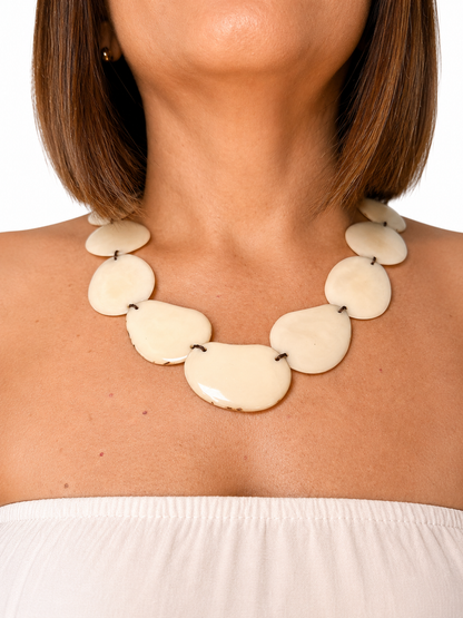 MÍSTIKA Tagua Sunlit Petals Necklace in Ivory – Women's neck showing a bold ivory tagua necklace with white strapless top | Místika Style