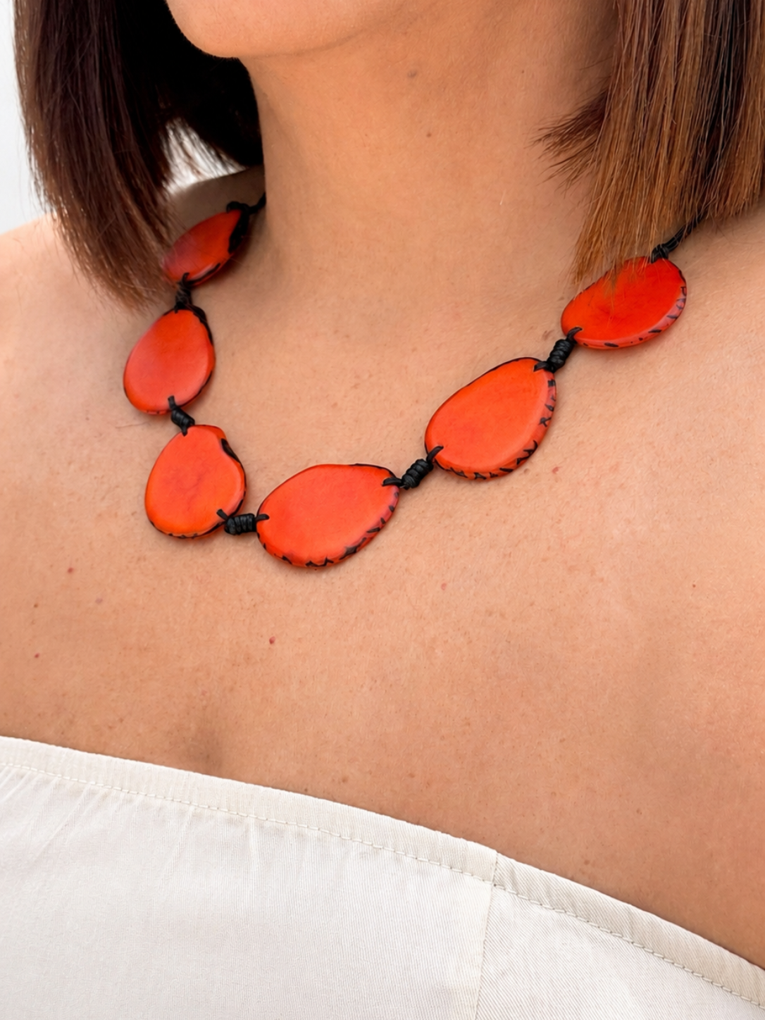 MÍSTIKA Tagua Sunlit Petals Necklace in Orange – Lifestyle photo worn on model with white top | Místika Style