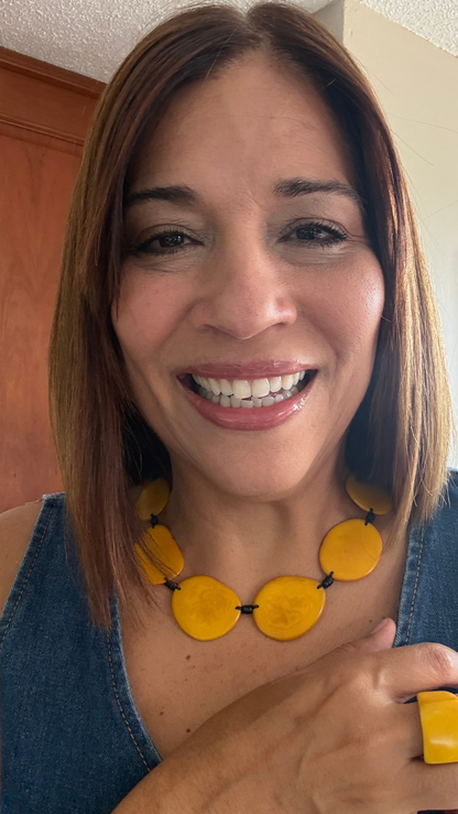 MÍSTIKA Tagua Sunlit Petals Necklace in Yellow – Smiling woman wearing bold yellow tagua necklace and ring with denim top | Místika Styl