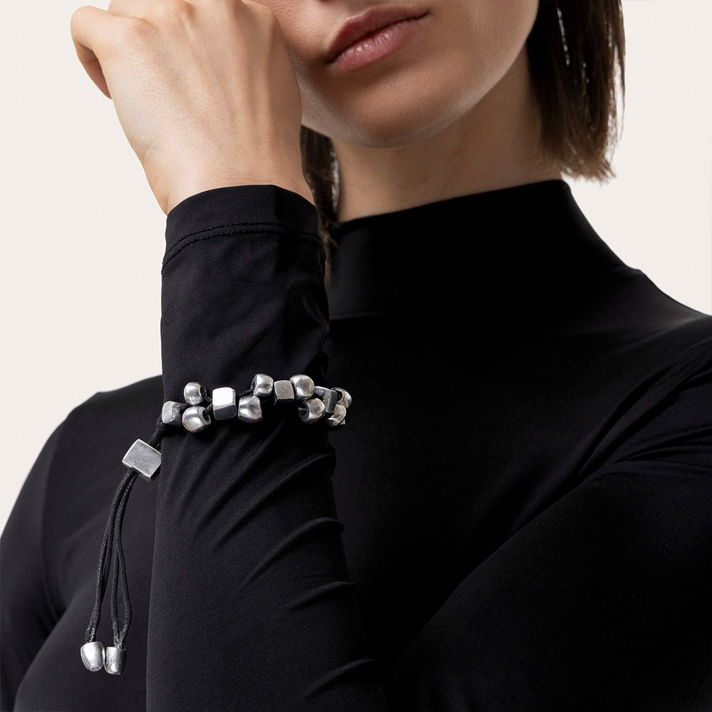 Vestopazzo Wire Sphere Cube Bracelet – Woman wearing bold silver sphere and cube bead bracelet on wrist with black turtleneck top | Místika Style